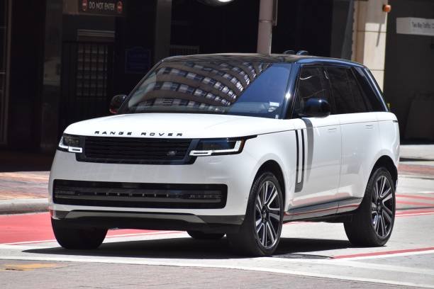 Houston, TX USA - 5/15/2024 - A portrait of a black and white Land Rover Range Rover SUV cruising in a downtown district